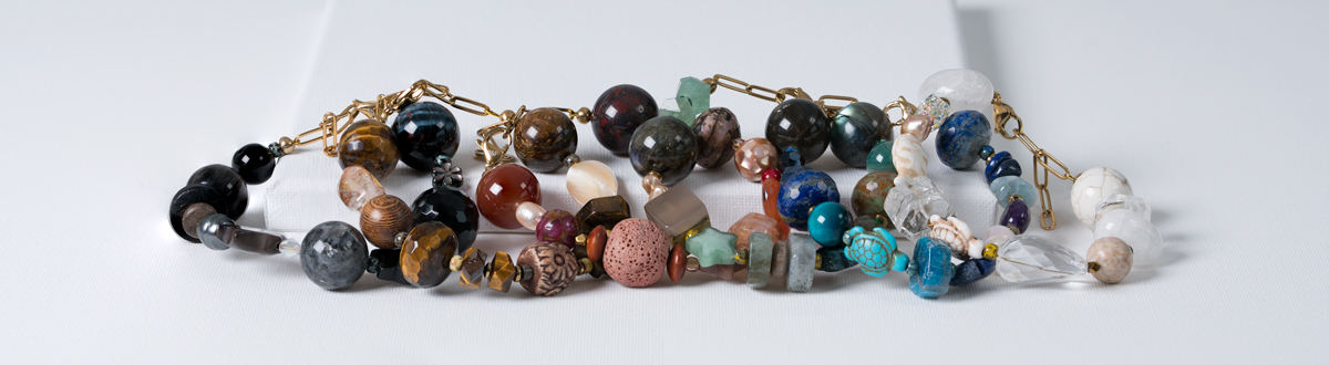Chunky edelsteen armband met grote kralen in verschillende tinten, parels en goudkleurige details.