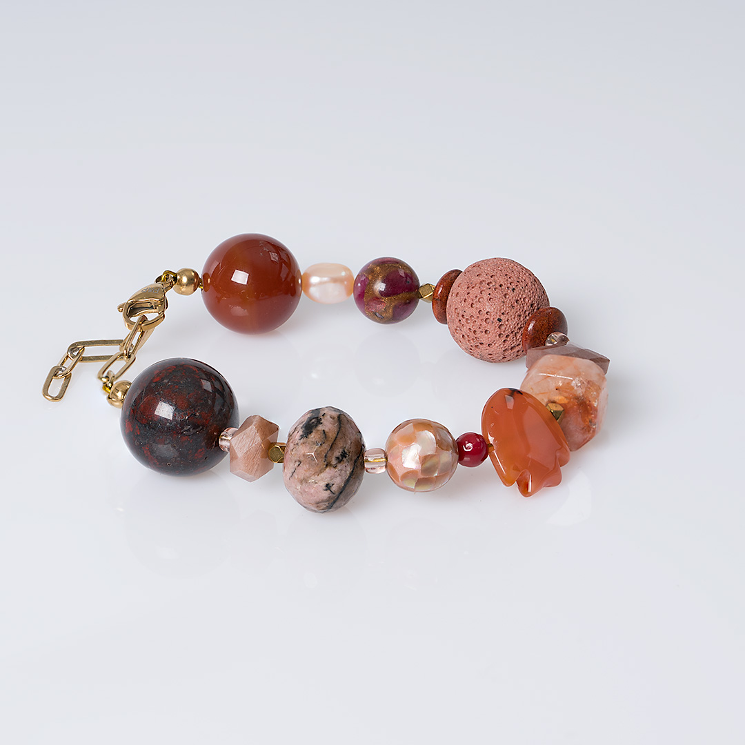 Chunky Sun oranje edelsteen armband met grote kralen in oranje en roze tinten, donkere stenen en goudkleurige details.